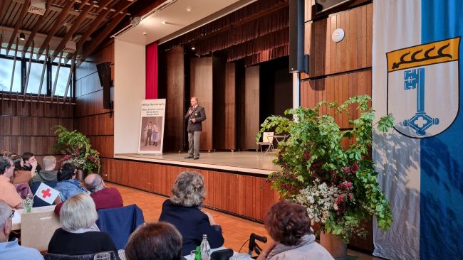 zu sehen sind Gäste und Bereitschaftsleiter Andreas Schober bei der Eröffnung des kulturellen Abends