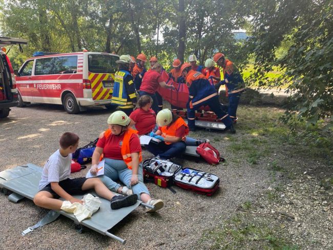 zu sehen sind Jugendrotkreuzler und Jugendfeuerwehrler bei einer gemeinsamen Übung