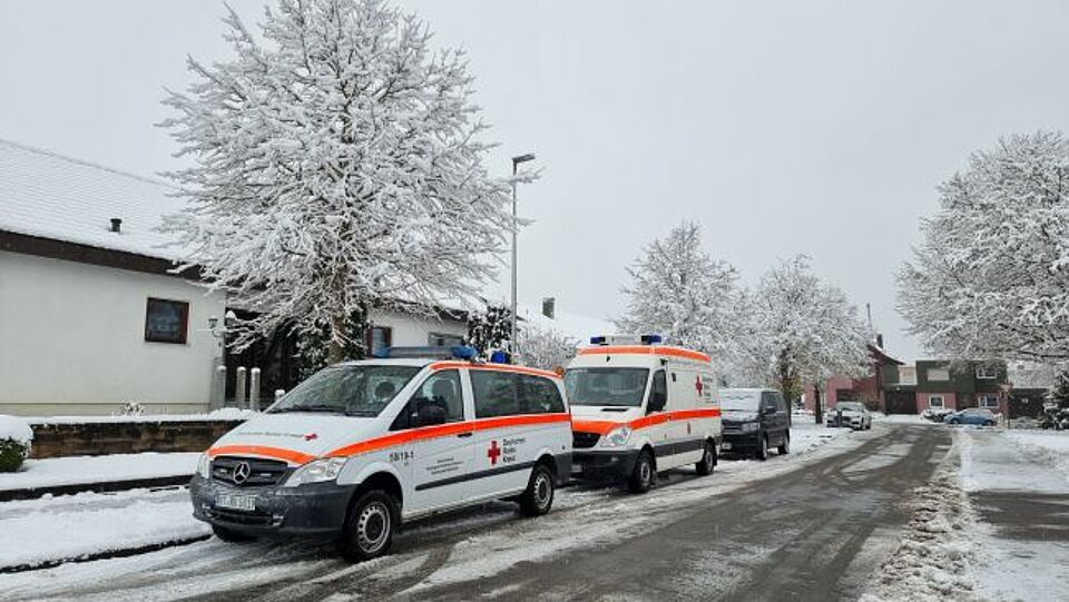 zu sehen sind zwei Fahrzeuge bei einem Gebäudebrand auf schneebedeckter Straße