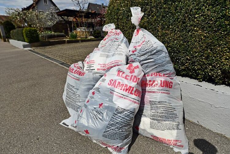 zu sehen sind Altkleidersäcke zur Sammlung am Straßenrand