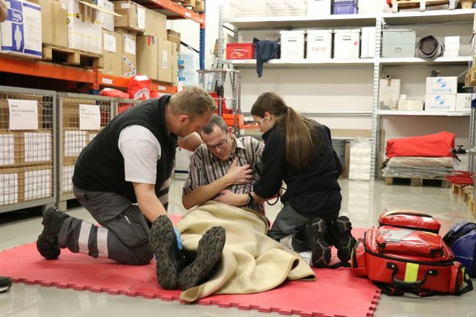 zu sehen sind zwei DRK-Helfer bei einem praktischen Fallbeispiel im Rahmen des Sanitätskurses