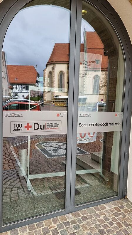 zu sehen ist der Eingang des Weilheimer Rathauses mit Infobanner zur DRK Ausstellung