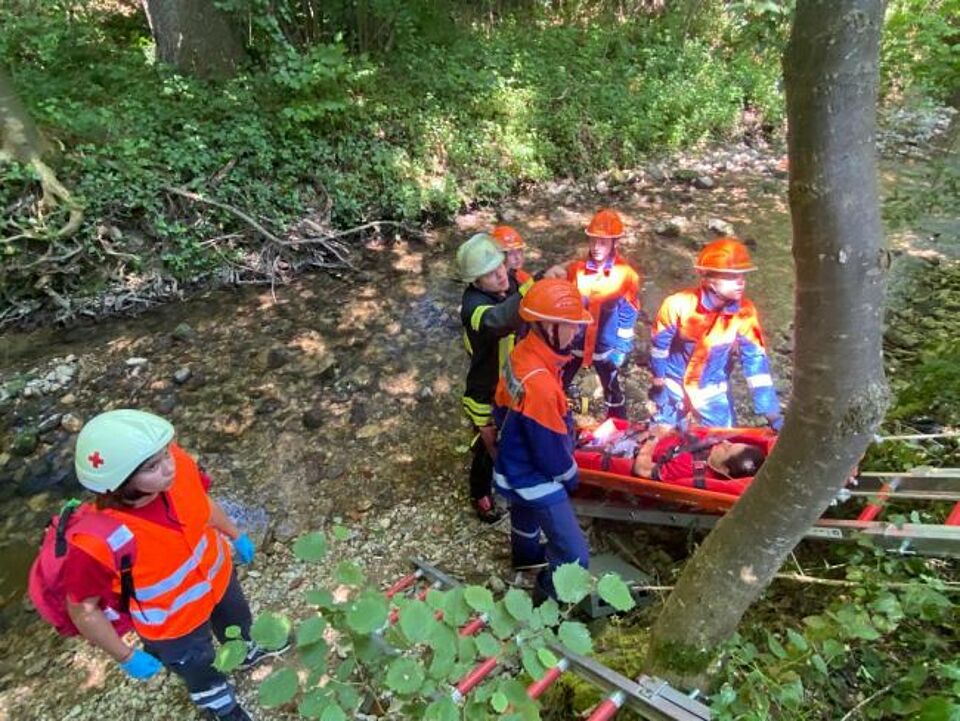 zu sehen sind Jugendfeuerwehrler beim Retten einer Person im Rahmen einer Übung mit dem Jugendrotkreuz