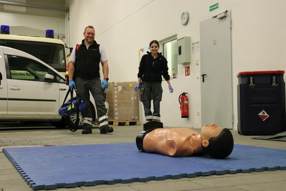 zu sehen sind zwei DRK-Helfer bei einem praktischen Fallbeispiel im Rahmen des Sanitätskurses
