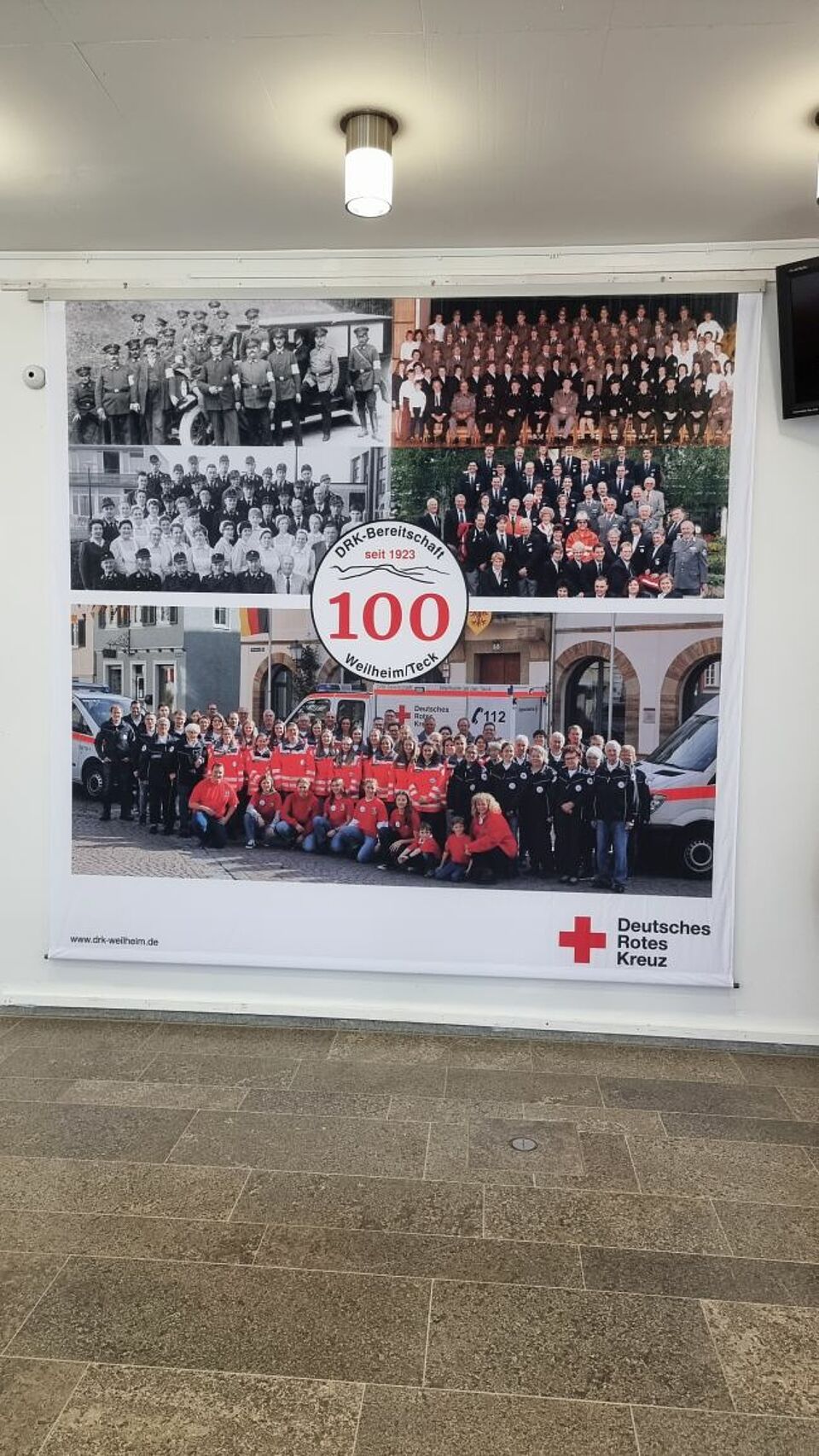 zu sehen ist ein Plakat zum 100-jährigen Jubiläum des DRK Weilheim mit Gruppenfotos aus verschiedenen Jahren
