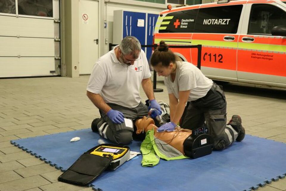 zu sehen sind zwei DRK-Helfer bei einem praktischen Fallbeispiel im Rahmen des Sanitätskurses
