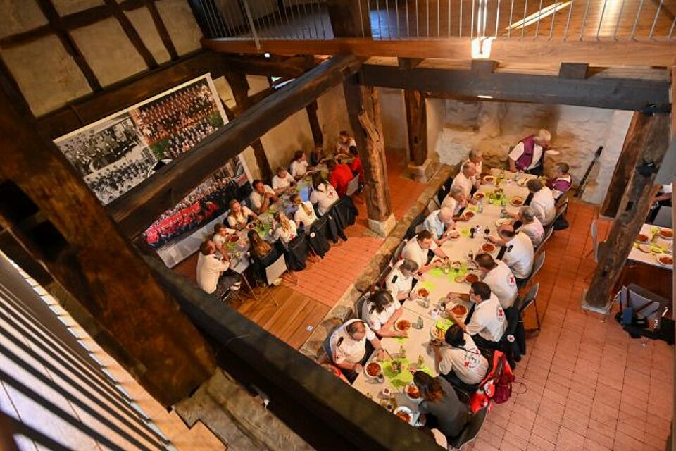 zu sehen sind DRK-Helfer bei einer Stärkung mit Essen und Getränken in der Schloßscheuer Weilheim
