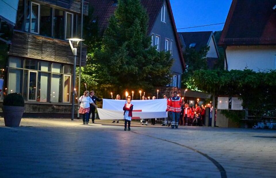 zu sehen sind Mitglieder des DRK beim Fackellauf durch die Innenstadt Weilheim