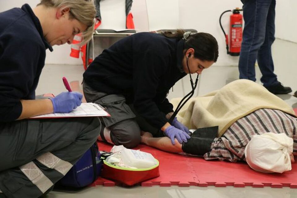 zu sehen sind zwei DRK-Helferinnnen bei einem praktischen Fallbeispiel im Rahmen des Sanitätskurses