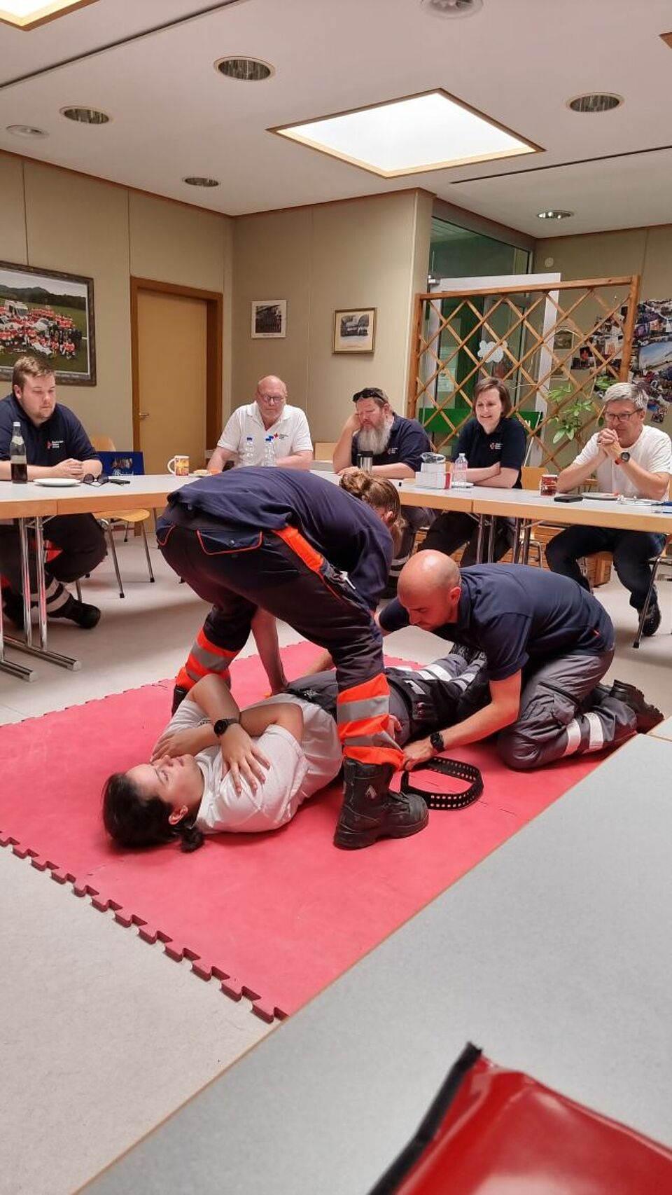 zu sehen sind zwei Helfer beim Traumatag wie sie eine Beckenschlinge am Patient anlegen
