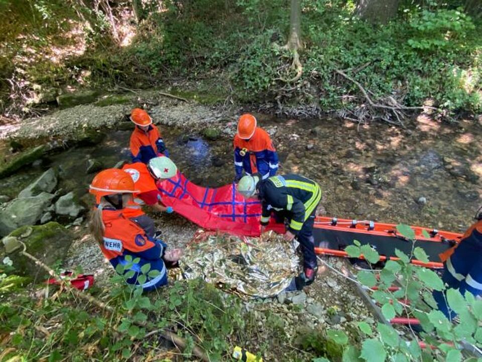 zu sehen sind Jugendfeuerwehrler beim Retten einer Person im Rahmen einer Übung mit dem Jugendrotkreuz